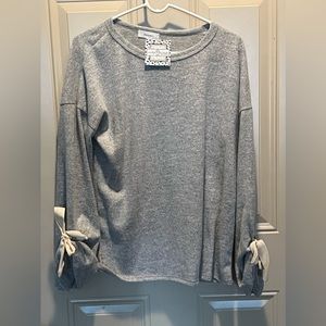 Never worn cute light grey sweatshirt with ties in sleeve